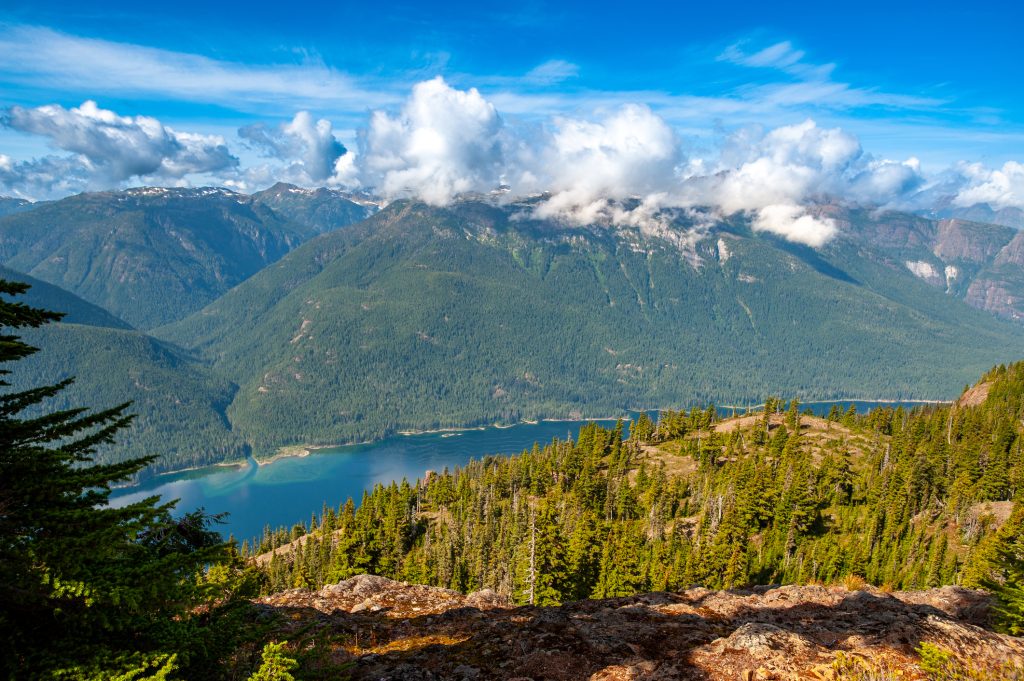 Forested mountains and a lake on Vancouver Island, showing the natural landscape that sustainable community design aims to protect.